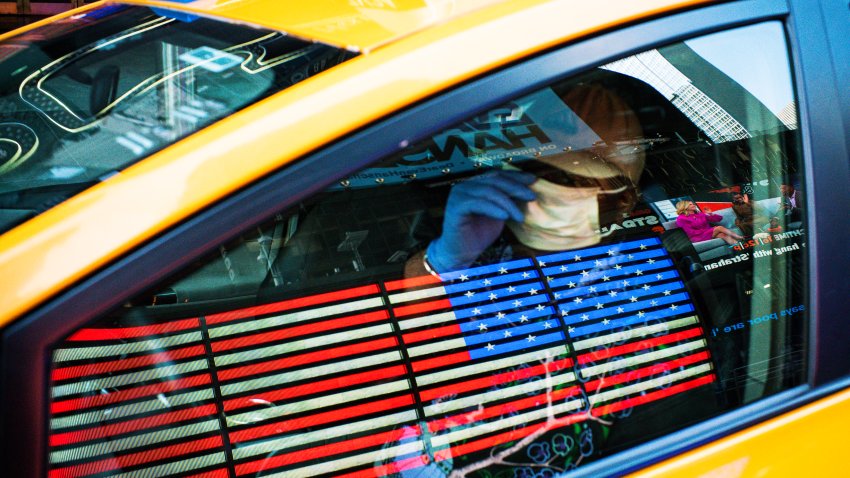 A taxi driver wears a face mask and gloves as he drives down Times Square on March 26, 2020 in New York City. Most cabdrivers are fearful of being exposed to the coronavirus that they prefer to stay home with no way to pay bills, while across the country schools, businesses and places of work have either been shut down or are restricting hours of operation as health officials try to slow the spread of COVID-19.